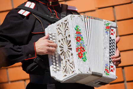 Musical instrument accordion in the hands of a male musician. The concept of culture and art.の写真素材