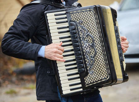 Musical instrument accordion in the hands of a male musician. The concept of culture and art.の写真素材