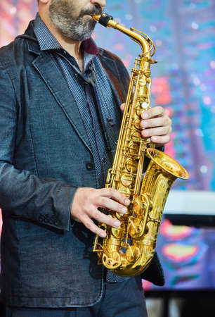Musical instrument saxophone in the hands of the artist. Concept of a concert, jazz or classical music.の写真素材