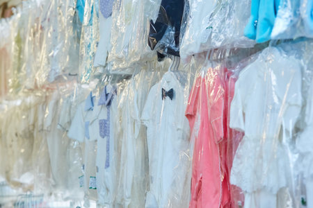 Goods items of clothing hang on the window in the store. Production and sale of children's clothing. Business in the textile industry.の写真素材
