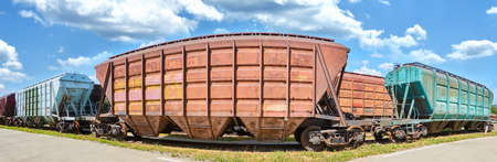 Panorama freight cars are parked and waiting for loading of industrial goods. Transportation of various materials over long distances.の写真素材