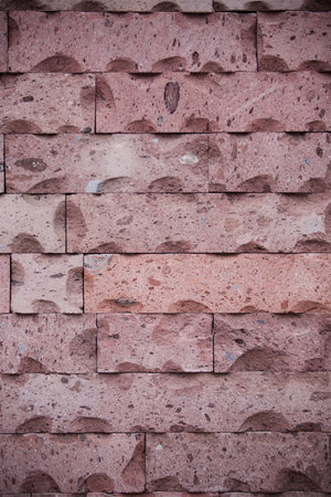 stone wall made of red tufa of an old Armenian Church