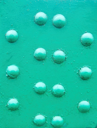 The texture of an old metal painted surface with rivets.の写真素材