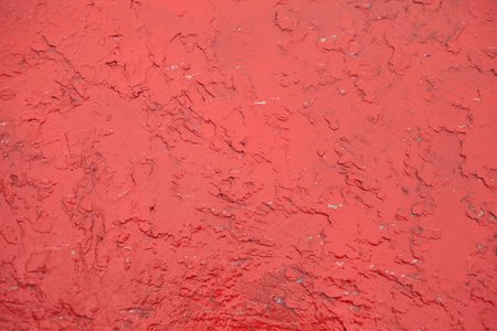 The texture of an old peeling metal surface painted with red paint.の写真素材
