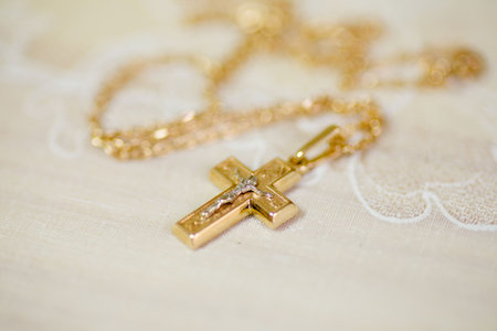 Christian cross to wear on the body after baptism. Material-gold. The concept of faith and religion.の写真素材