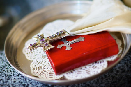 The Christian cross lies on top of the book of the Bible. The concept of faith and religion.