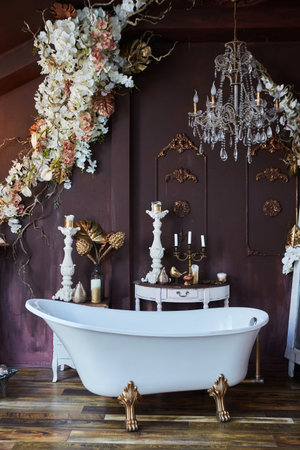 The interior of the room is in vintage style. Studio for romantic pictures. A large bathtub. Decoration with flowers.の写真素材