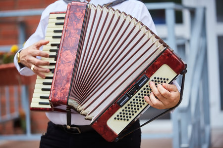 Musical instrument accordion in the hands of a male musician. The concept of culture and art.の写真素材