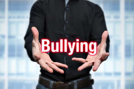 Young man holds lettering bullying in the handsの写真素材