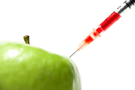 Green apple with syringe and red liquid, isolatedの写真素材
