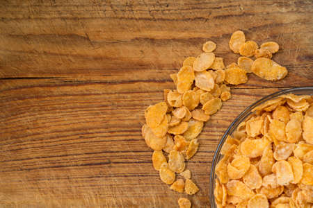A lot of corn flakes on brown wood backgroung
