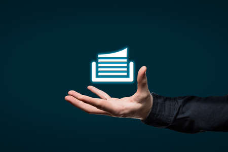 Businessman holds a virtual icon in his handの写真素材