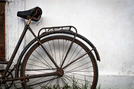 Old Rusty Bicycle leaning against a white house wallの写真素材