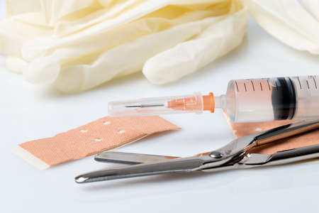 Plasters and bandages with Scissors and syringe on a white backgroundの写真素材