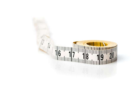 Yellow white tailor tape measure to take measurements and measureの写真素材