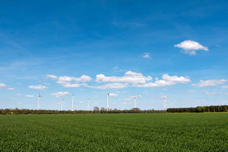 Wind turbine in front of blue cloudy skyの写真素材