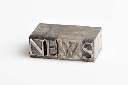 The word News in old lead letters on a white backgroundの写真素材