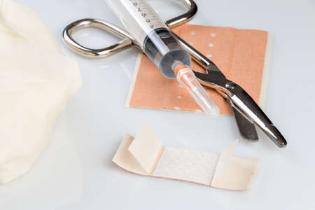 Plasters and bandages with Scissors and syringe on a white backgroundの写真素材