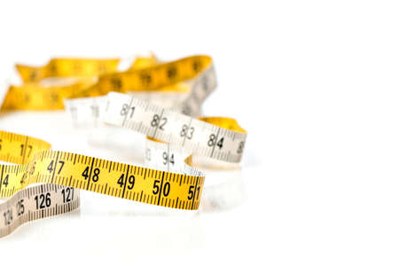 Yellow white tailor tape measure to take measurements and measureの写真素材