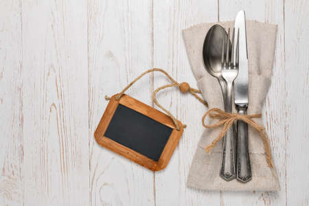 Cutlery is in a napkin wrapped on an old tableの写真素材