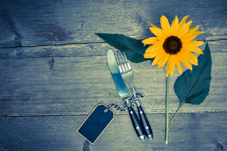 Cutlery is an old table with a yellow sunflowerの写真素材