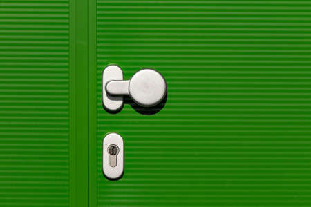 Green hall door with green door and silver colored door handleの写真素材