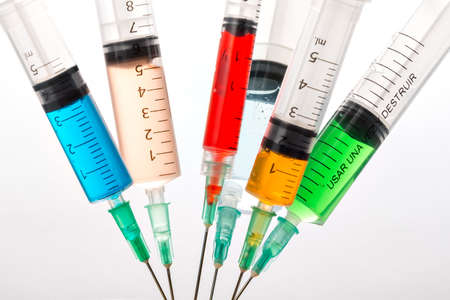 Various syringes filled with colored liquids, closeup isolatedの写真素材