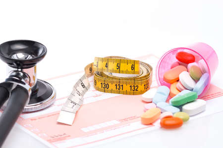 Tape measure and pills on a white table