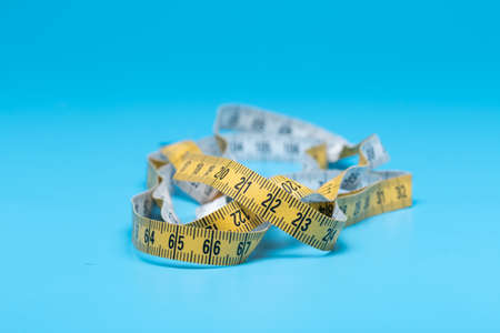 Yellow white tailor tape measure to take measurements and measureの写真素材