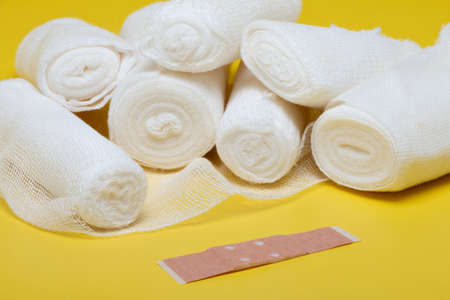 Plasters and bandages with Scissors and syringe on a yellow background