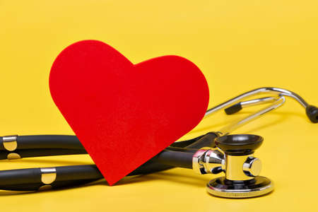 Stethoscope with red heart on yellow backgroundの写真素材