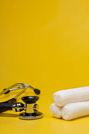 Plasters and bandages with Scissors and syringe on a yellow backgroundの写真素材