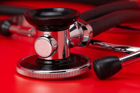 Stethoscope, medical instrument, close-up isolated with red backgroundの写真素材