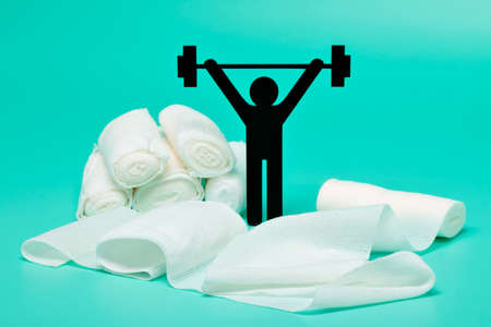 Weight lifting pictogram, Plasters and bandages with Scissors and syringe on a white backgroundの写真素材