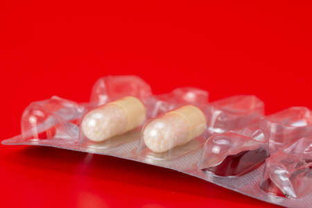 Blister of tablets isolated on a red background