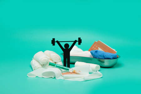 Weight lifting pictogram, Plasters and bandages with Scissors and syringe on a white backgroundの写真素材