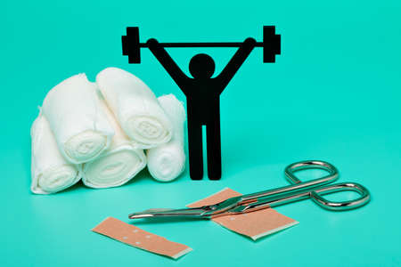 Weight lifting pictogram, Plasters and bandages with Scissors and syringe on a white backgroundの写真素材