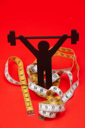 weight lifting pictogram, tape measure and red backgroundの写真素材