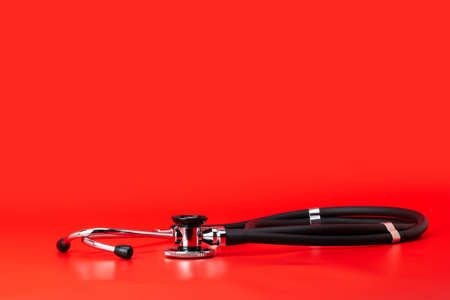 Stethoscope, medical instrument, close-up isolated with red backgroundの写真素材