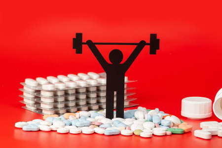 weightlifting pictogram with pills and red backgroundの写真素材