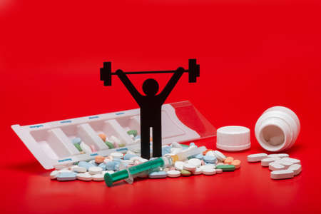 weight lifting pictogram with pills and red backgroundの写真素材