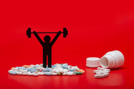 weight lifting pictogram with pills and red backgroundの写真素材