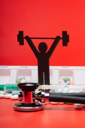 weight lifting pictogram with pills and red backgroundの写真素材