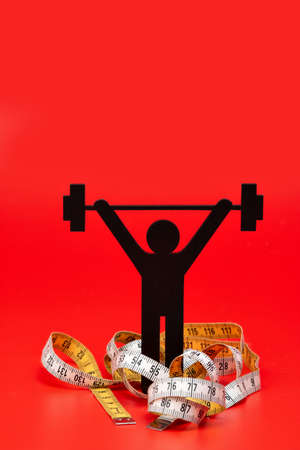 weight lifting pictogram, tape measure and red backgroundの写真素材