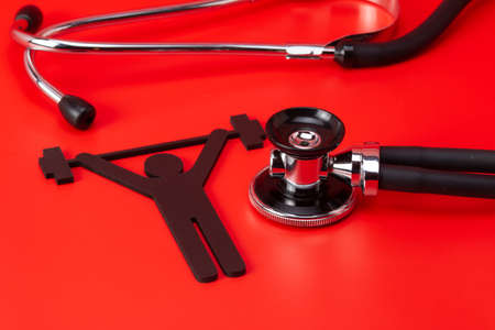 Weight lifting pictogram, Stethoscope, close-up isolated with red backgroundの写真素材
