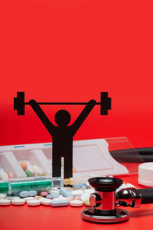 weight lifting pictogram with pills and red backgroundの写真素材