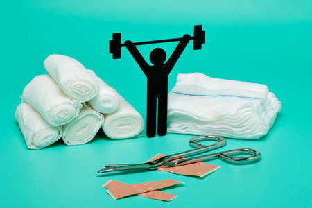 Weight lifting pictogram, Plasters and bandages with Scissors and syringe on a white backgroundの写真素材