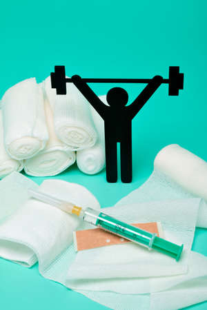 Weight lifting pictogram, Plasters and bandages with Scissors and syringe on a white backgroundの写真素材