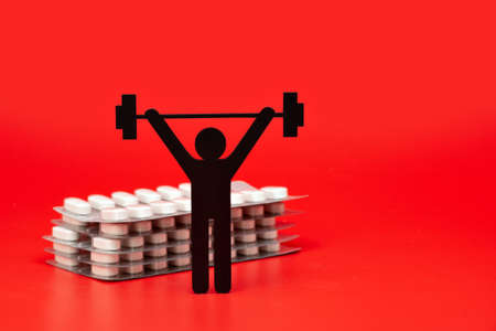 weightlifting pictogram with pills and tape measure, red backgroundの写真素材