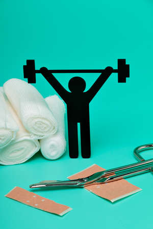 Weight lifting pictogram, Plasters and bandages with Scissors and syringe on a white backgroundの写真素材